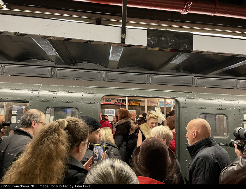 People dessed up in amazing costumes posing next to the NYCTA Holiday Train at 2nd Avenue Station on Manhattans Lower East Side